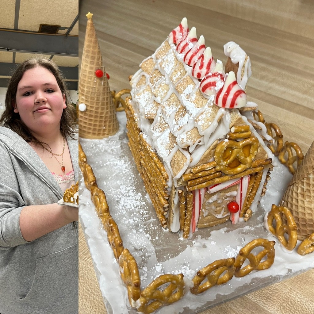 Student poses with their winning Gingerbread House creation.