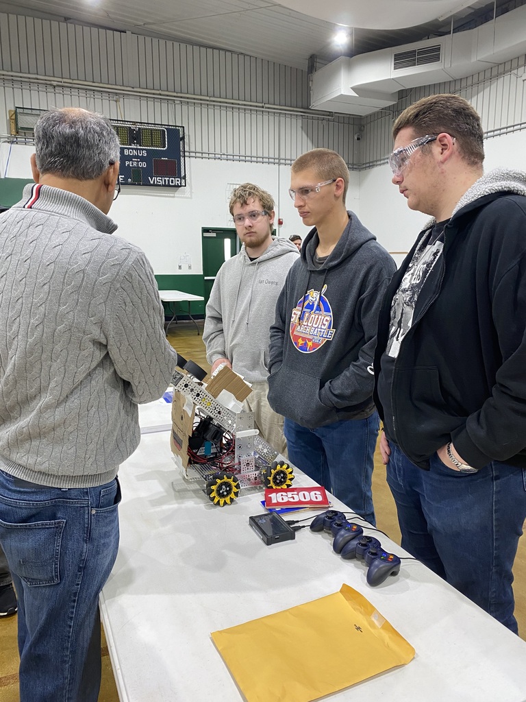 Ian Owens, Nicholas Thies, Noah Foster await inspection of the robot for competition.