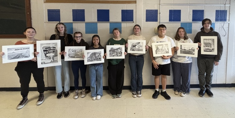Students holding their artwork