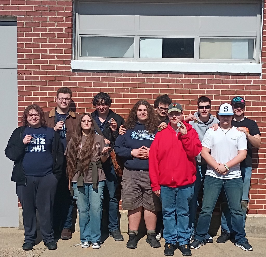 A group of high school students in front of a brick wall