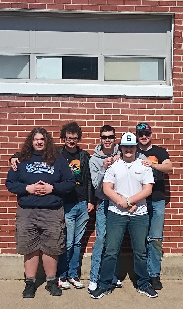 A group of high school students in front of a brick wall. Varsity team