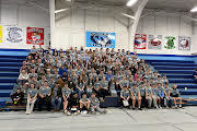 Large group of students sitting in the bleachers in front of a Salem Tigers sign. 