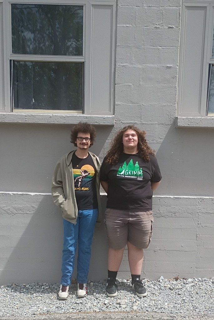 Two students standing next to each other, posing for a picture. 