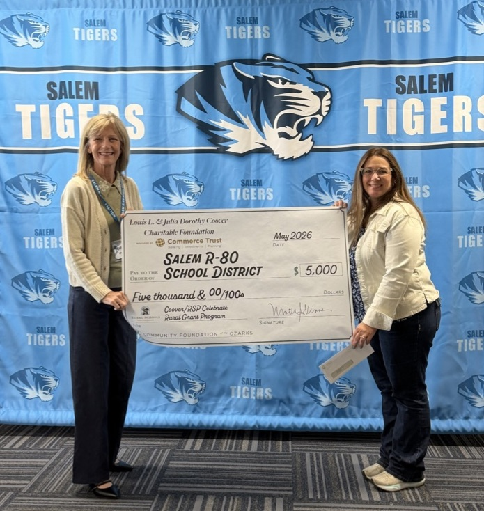 Mrs. John receiving a grant check for $5,000