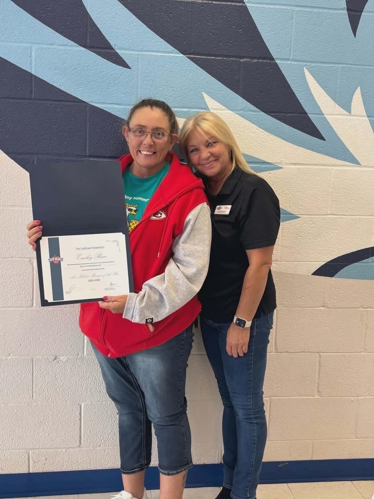 Emiley Raw stands with Chasity Harris as Emiley displays her Kitchen Manager of the Year certificate from Opaa! Food Management.