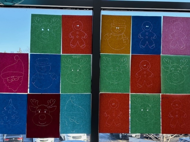 pushpin art hanging in window with holiday designs