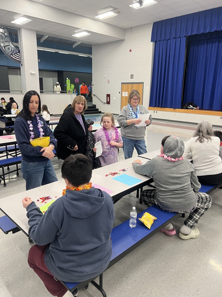 Students and staff participating in a beach-themed bingo activity in the school cafeteria.