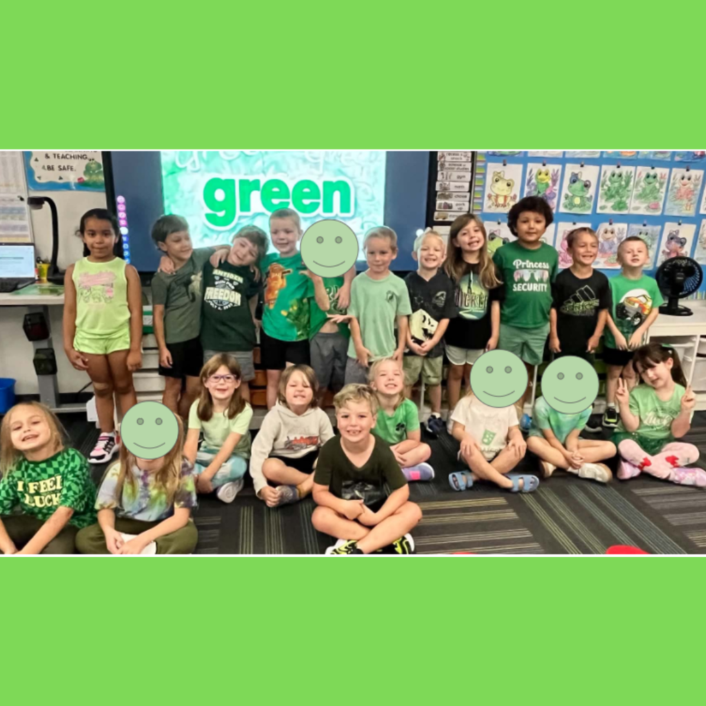 Young students dressed in green outfits gathered for a photo in front of a screen displaying "green."