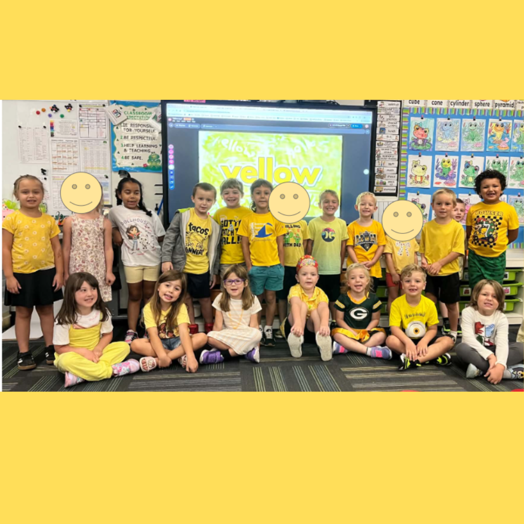 Group of elementary school students wearing yellow shirts gathered in a classroom for color day.