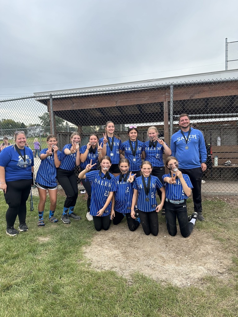 Salem softball team and coaches posing with medals on the field, smiling and making holding up the number 2 in front of a dugout.