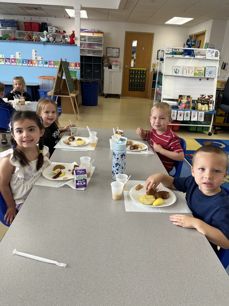 4K students sitting at a table tasting apples