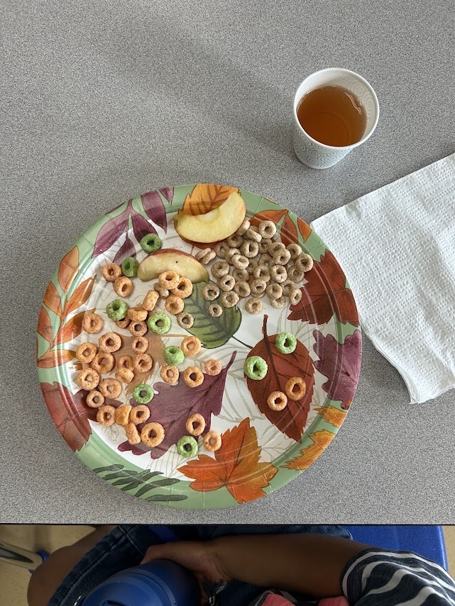 Elementary students sitting around a classroom table during a snack time activity.