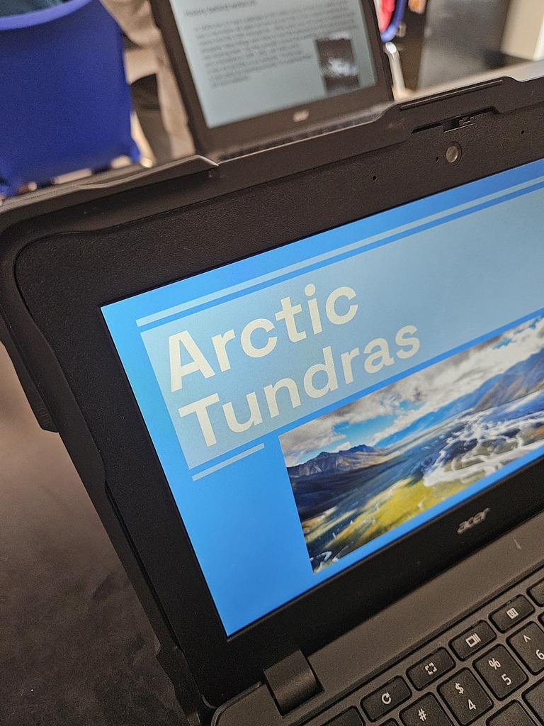 Close-up of a student's laptop showing a presentation title slide for "Arctic Tundras."