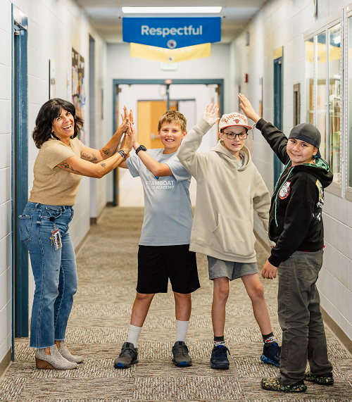 SMS Principal Michelle Saab gives high fives to students in the hallway