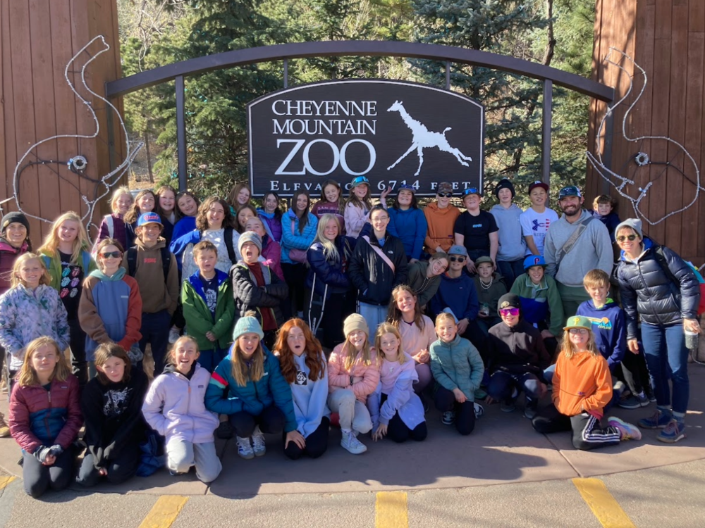 Crest students and staff in front of zoo sign