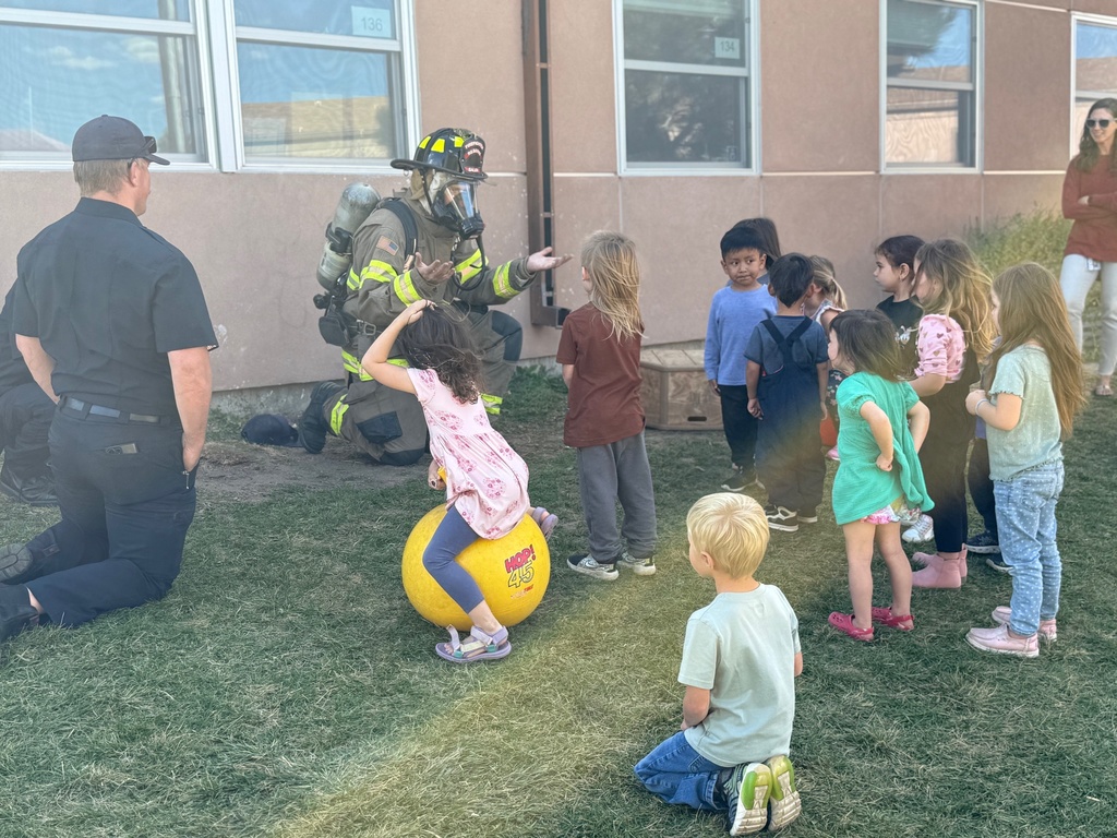 IMG_4117 A group of children are looking at a fireman with all of his equipment on.