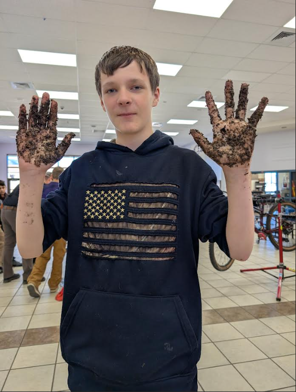 On of our 7th grader's getting his hands dirty helping GARNA make "seed bombs" to help pollinate our trails!