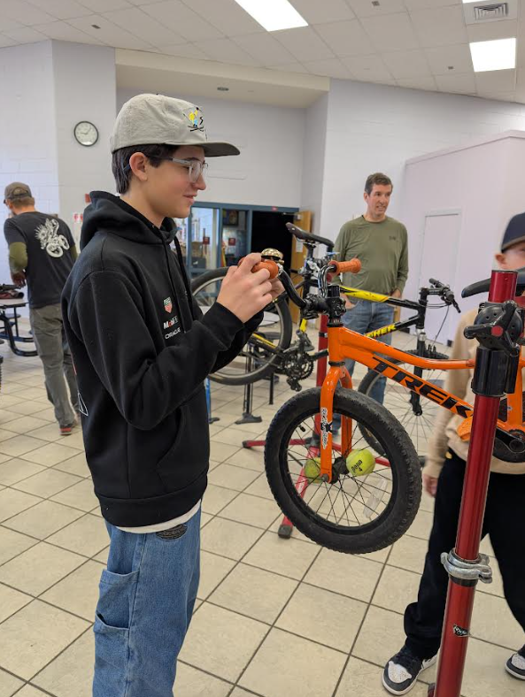 One of our 7th graders helping tune bikes with the help of some of our community experts!