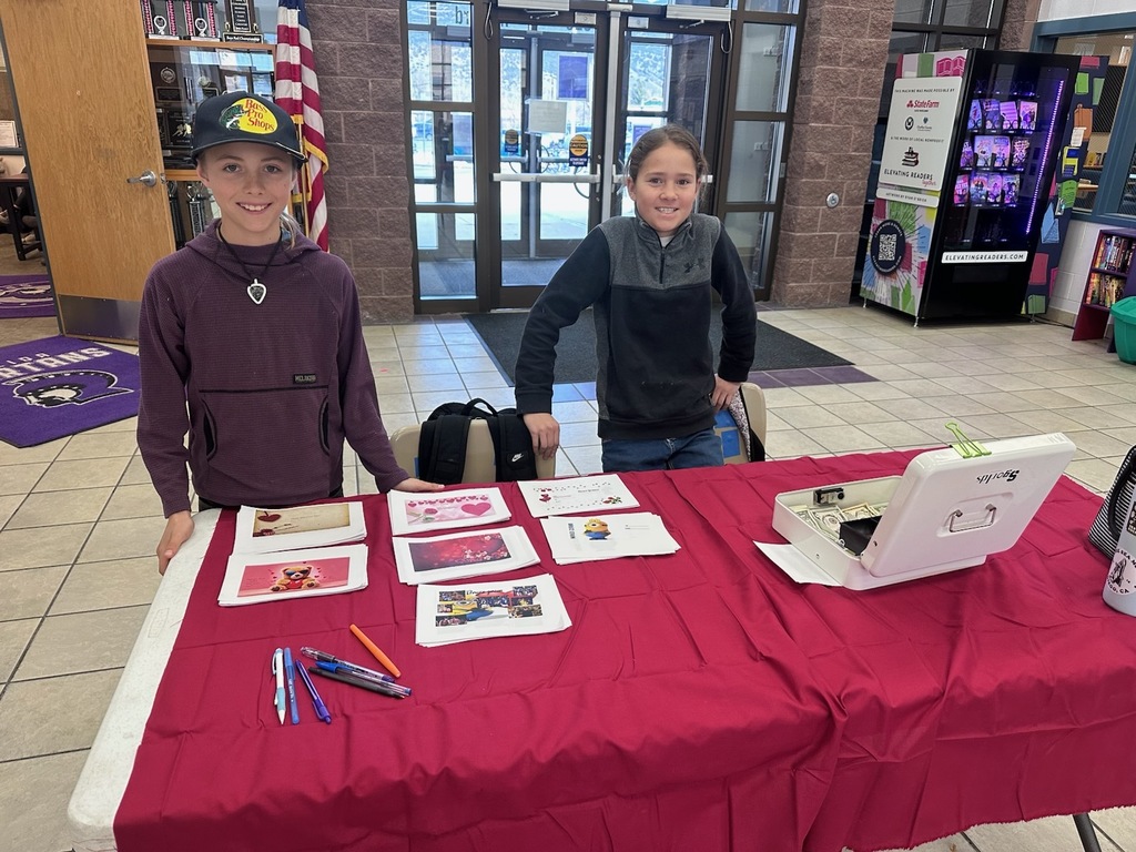 Two students selling Valentine's Grams at a red table