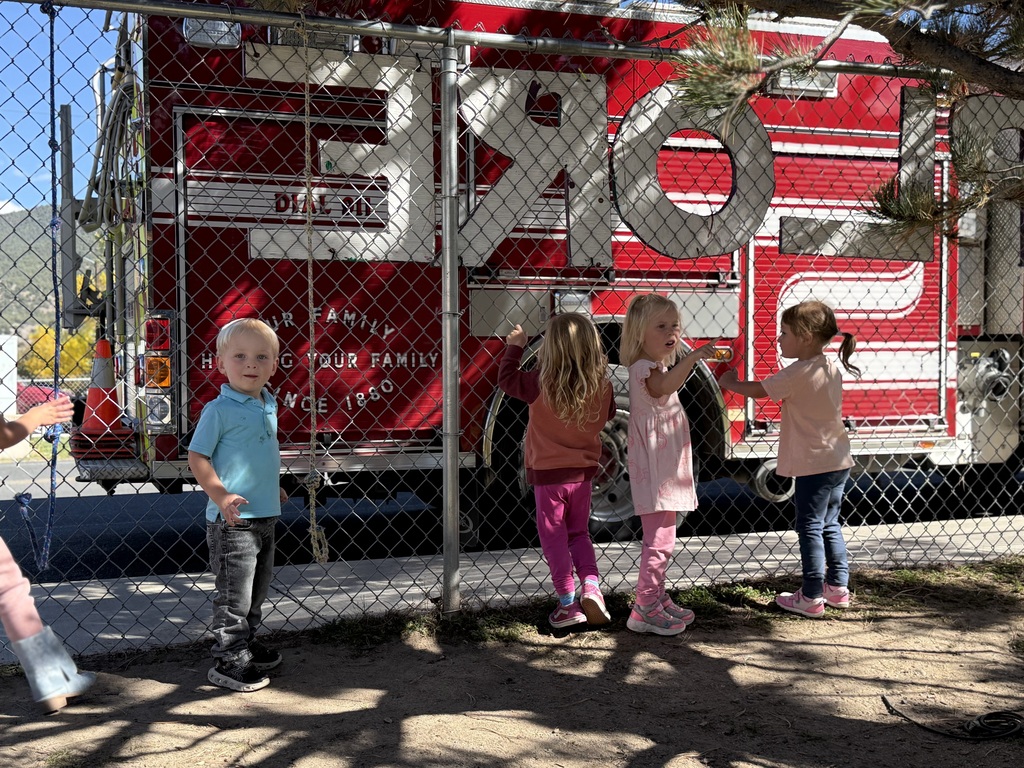 ECC students look at the fire truck that is parked outside the playground.