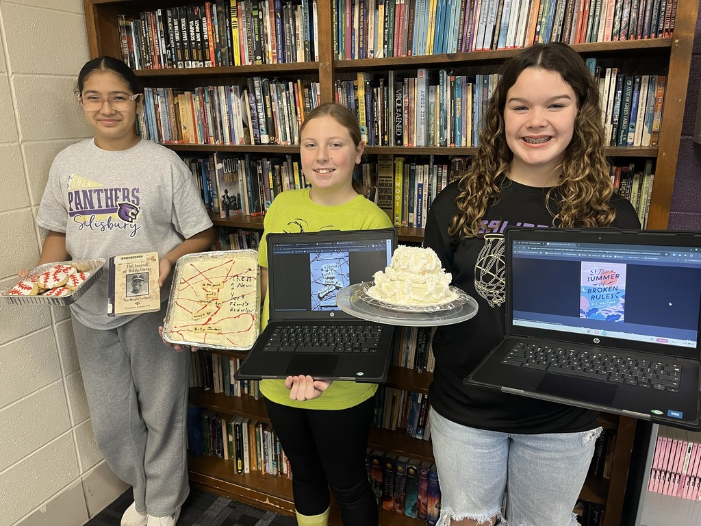 8th Grade students display baked goods and scrapbooks as part of second quarter book reports.