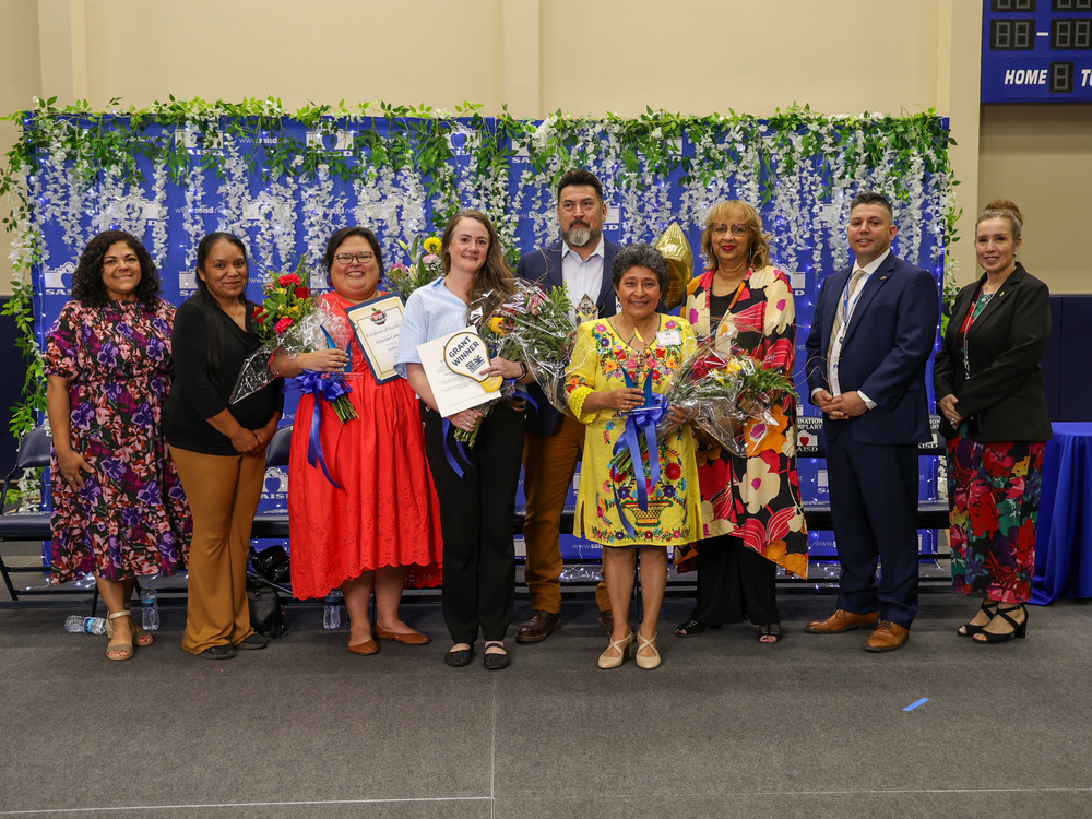 Teachers and principals of year with flowers, board members and executives