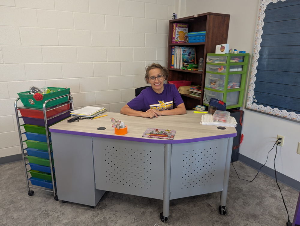 Teacher sits at desk