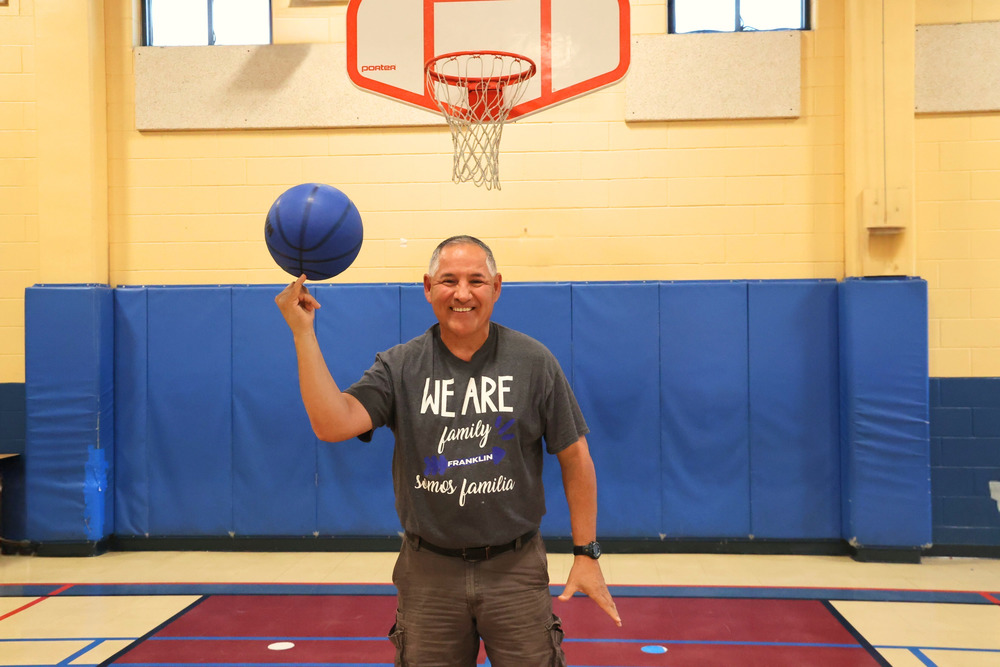 Man spins basketball in gym
