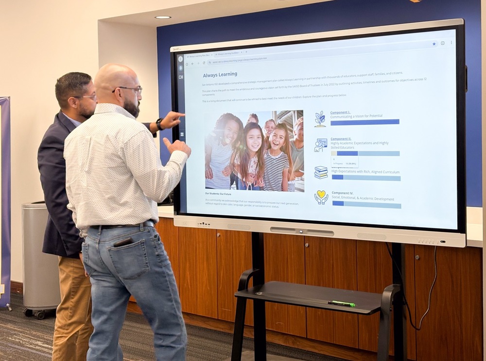 Two men look at computer screen