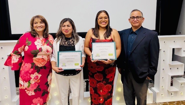 Two students with awards stand with woman and man