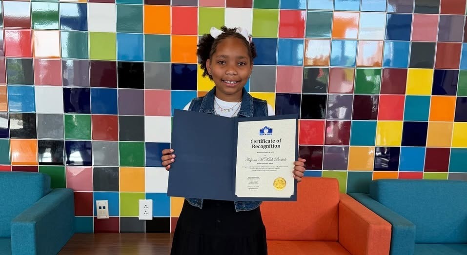 Female student holding board recognition