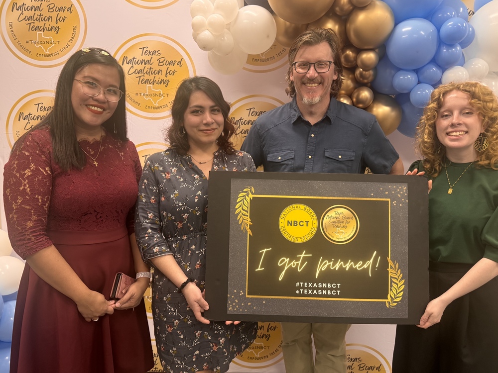 Three teachers hold "I Got Pinned" sign