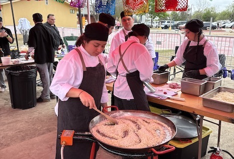students in culinary team cooking paella