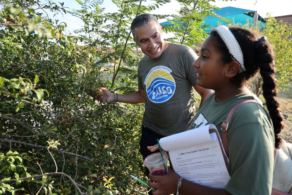 Superintendent Aquino and student in hands on garden