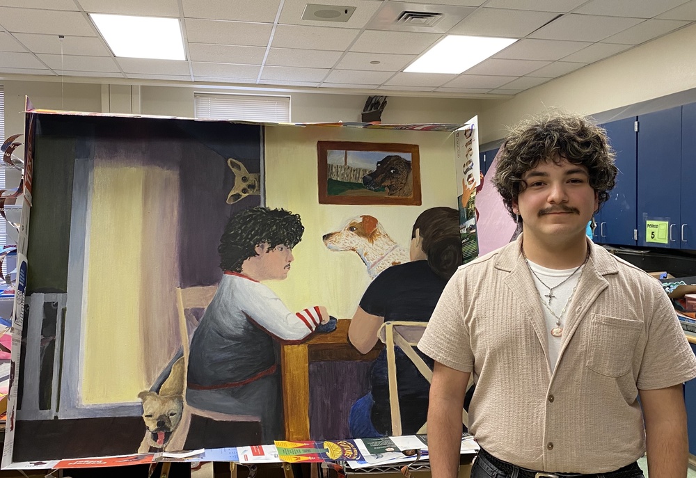 Male student stands in front of painting