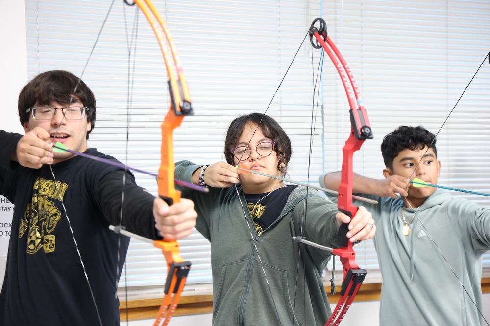 Three students with bow and arrow