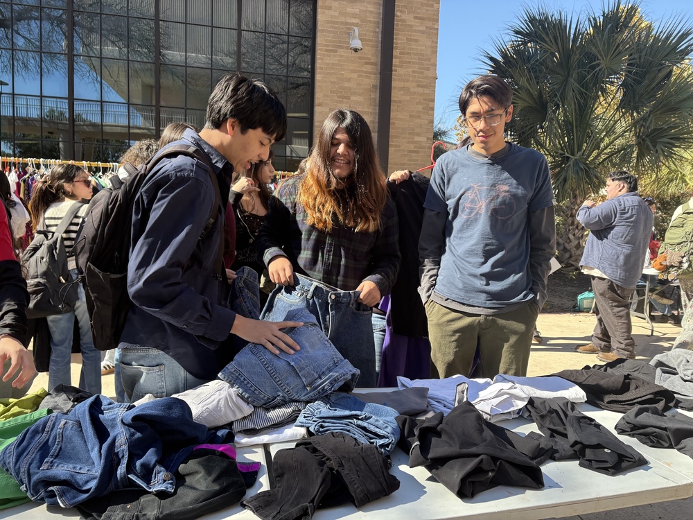 Three students examine jeans