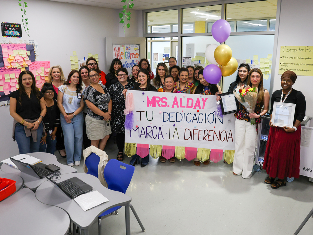 Group of people holding banner and balloons