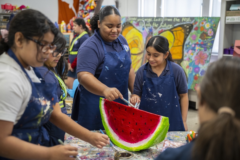Girls painting a watermelon papier mache