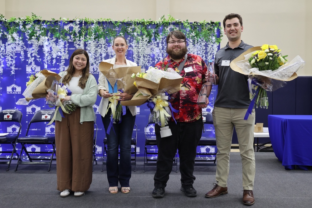 Three adults holding bouquets