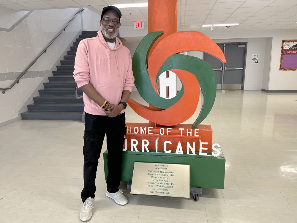 Mr. Reese stands in front of Hurricanes sign
