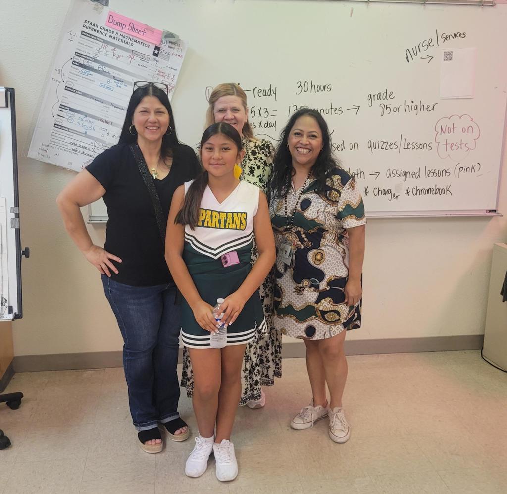 Teachers, family in front of white board