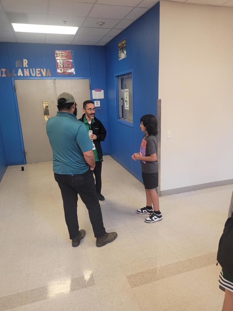 Family, teacher in front of blue room