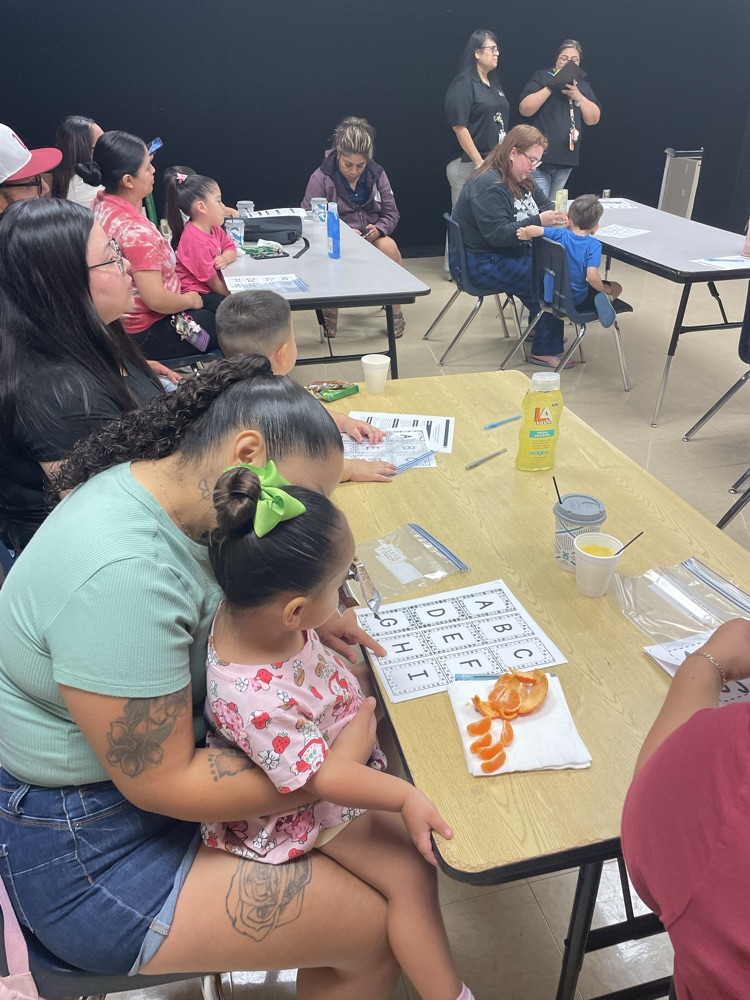 group of students and parents working on a letter activity