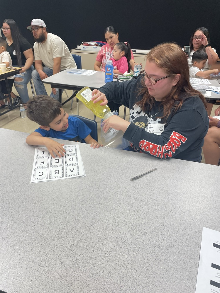 group of students and parents working on a letter activity