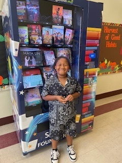 Boy Smiling by the Book Vending Machine
