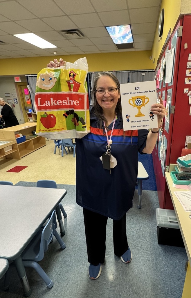 teacher holding attendance award 
