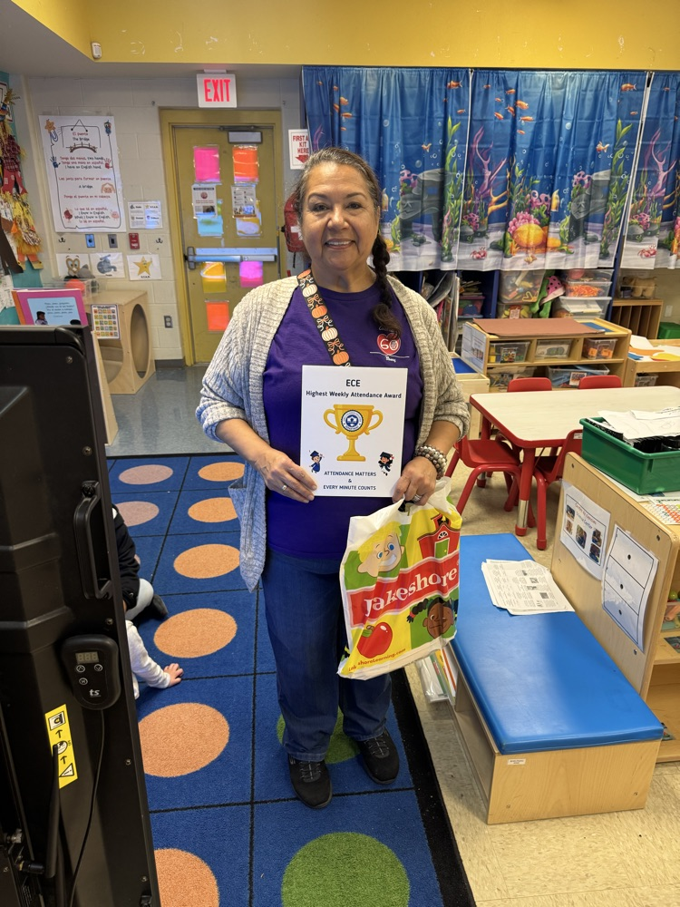 teacher holding attendance award 