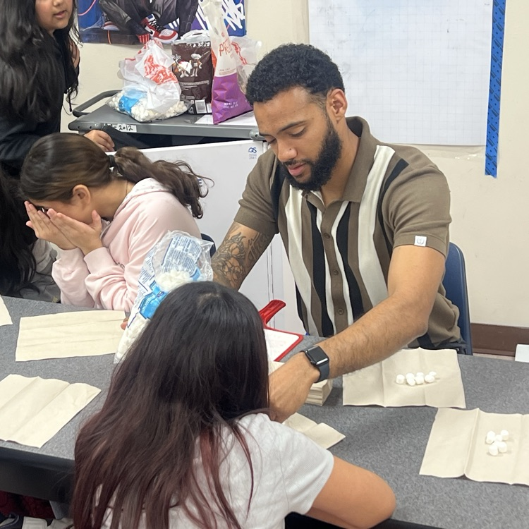 mr. Thomas passes out the items for the days lesson.