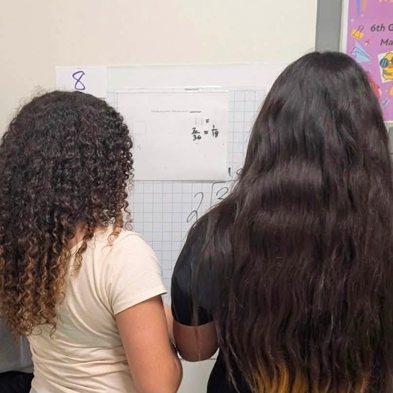 Girls solve math problems on wall